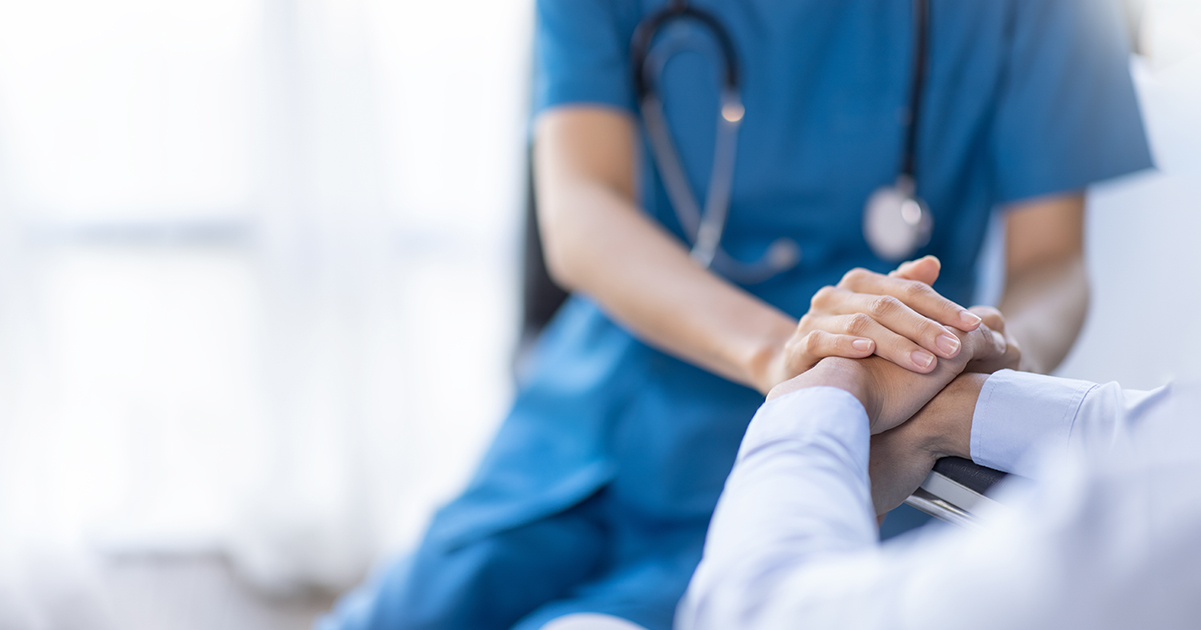 Nurse holds patient's hand. Credit / Shutterstock