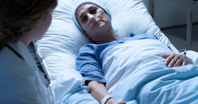 Dying woman lies in hospital bed. (Stock Image). Credit / Shutterstock