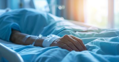 Patient lies in hospital bed. Credit / Shutterstock