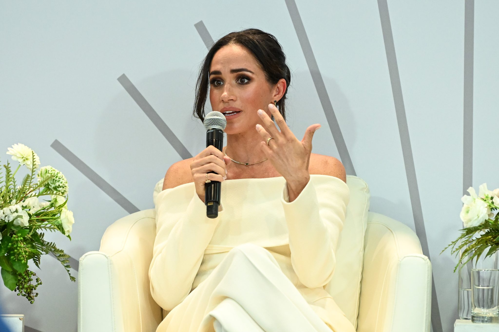 Meghan Markle siedzi w fotelu i mówi do mikrofonu