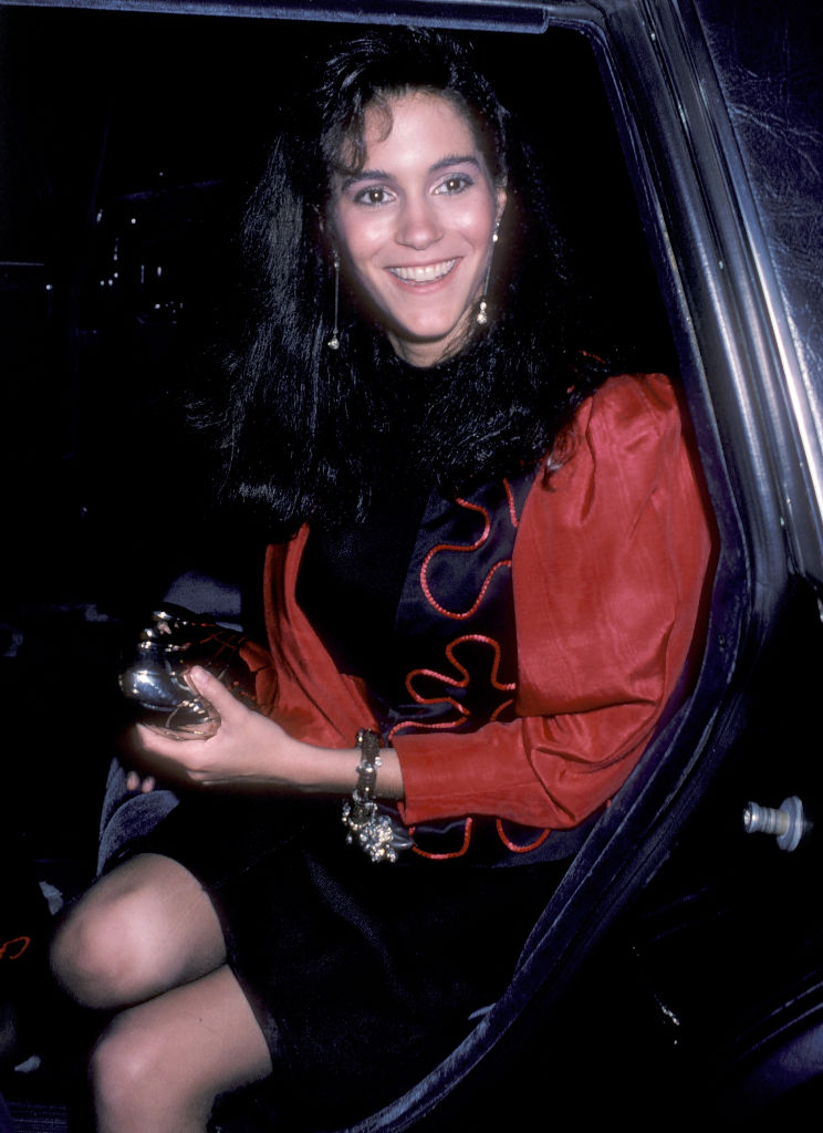 uśmiechnięta Jami Gertz siedzi w samochodzie