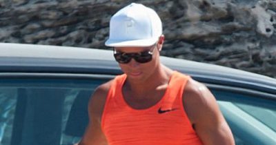 Cristiano Ronaldo w białej czapeczce z daszkiem i pomarańczowej koszulce na ramiączkach