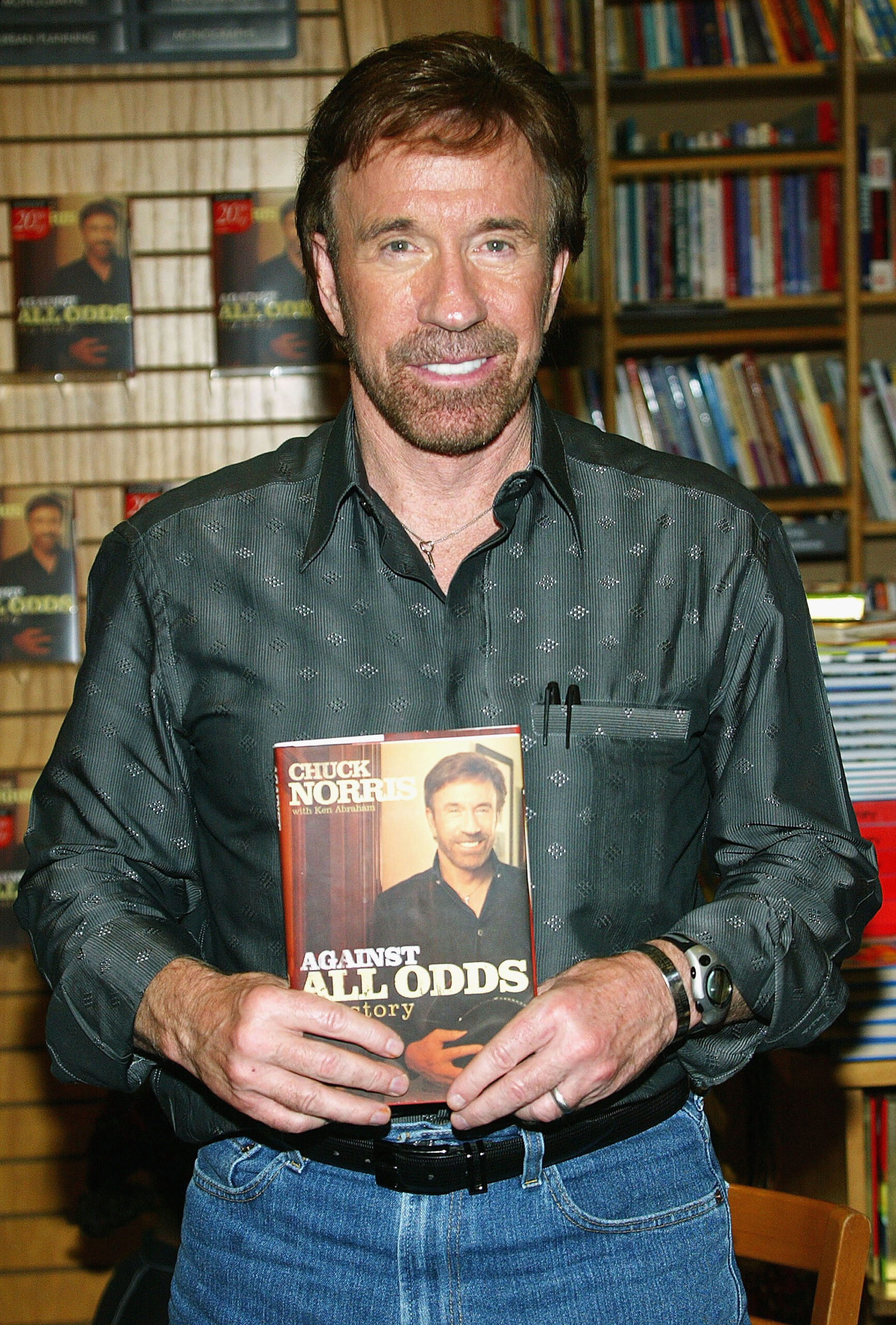  Chuck Norris trzyma w ręku swoją biografię