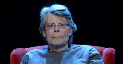 mężczyzna w okularach siedzi na fotelu