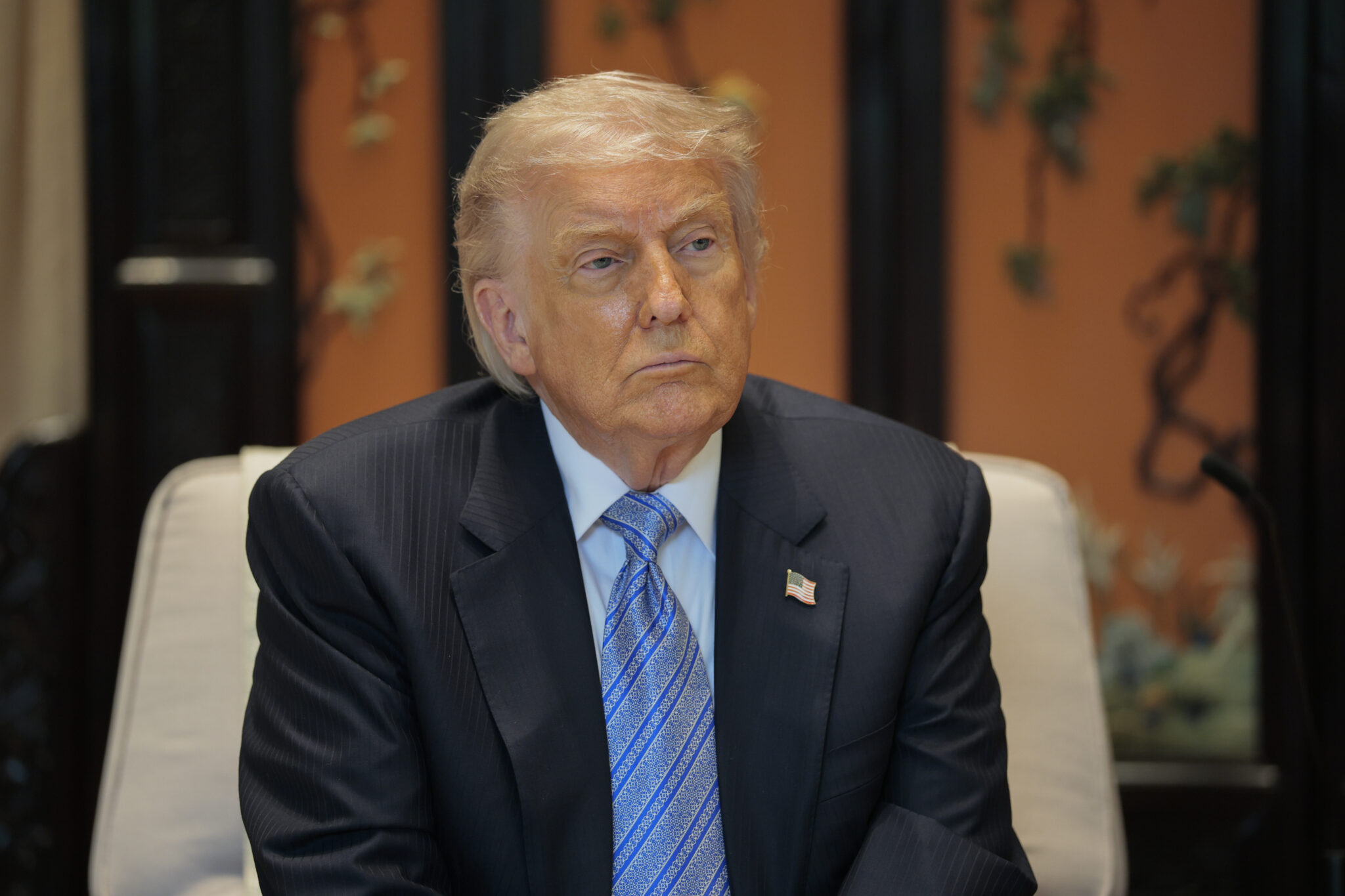 Donald Trump siedzi w fotelu na spotkaniu z prezydentem Chin Xi Jinpingiem 