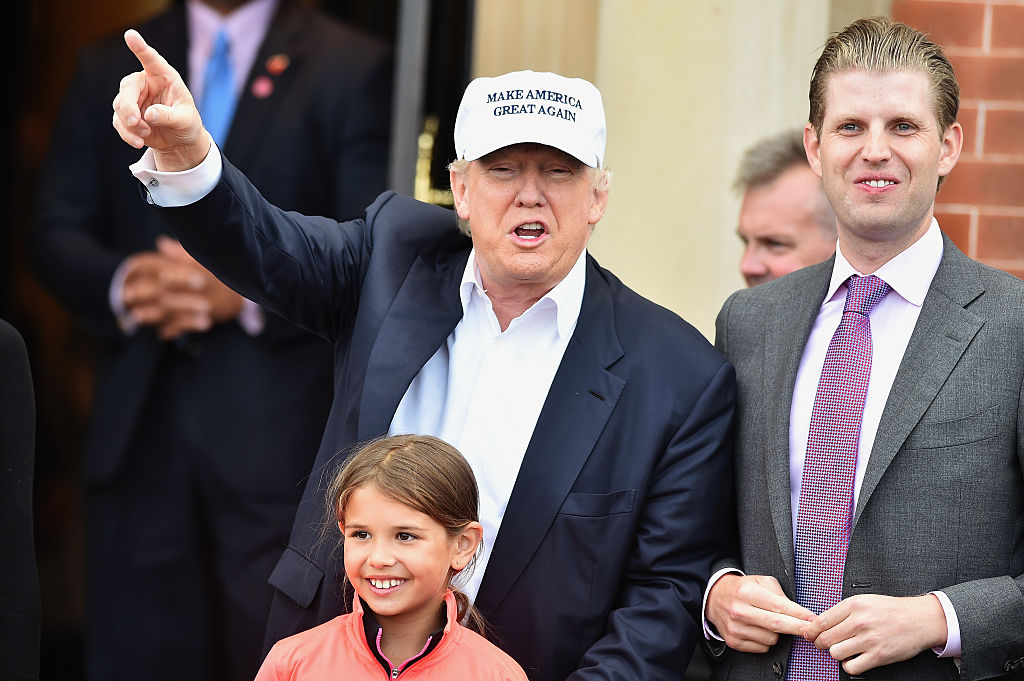 Donald Trump w czapeczce z daszkiem w towarzystwie mężczyzny i dziewczynki