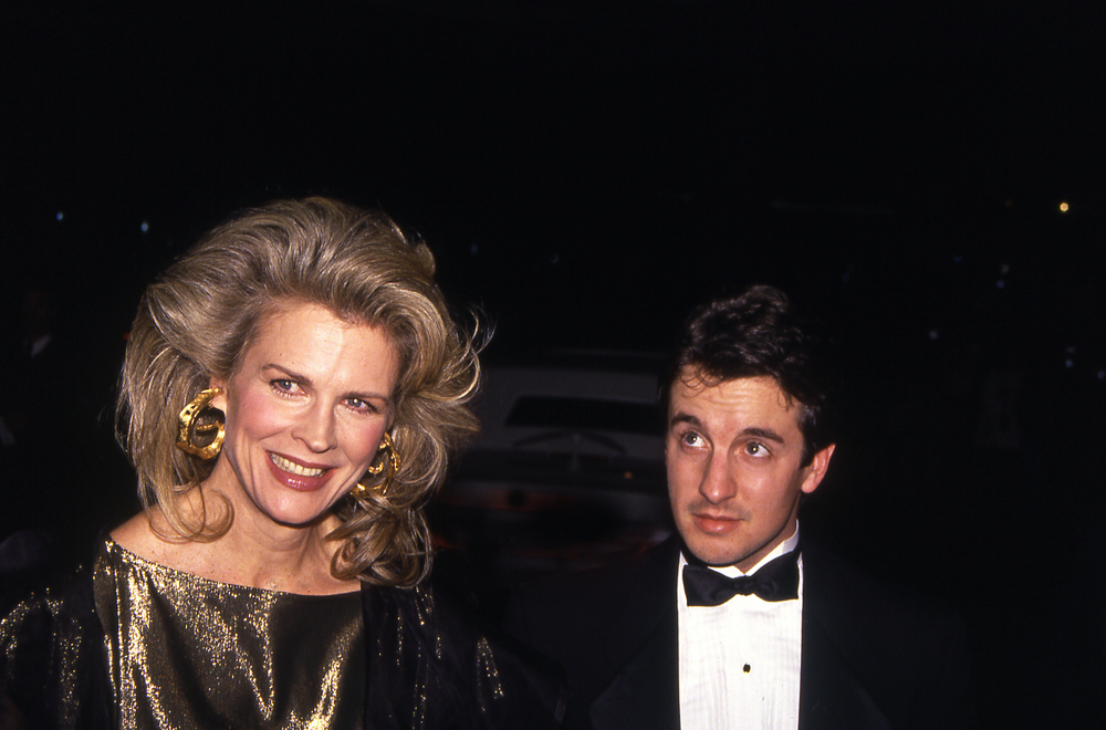 Candice Bergen w złotej kreacji i dużych kolczykach obok mężczyzny w muszce