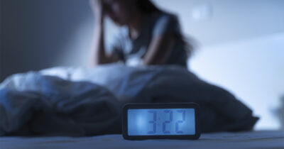 Uneton ihminen ja herätyskello. Shutterstock.