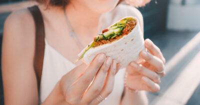 Nainen syömässä wrappia. Shutterstock