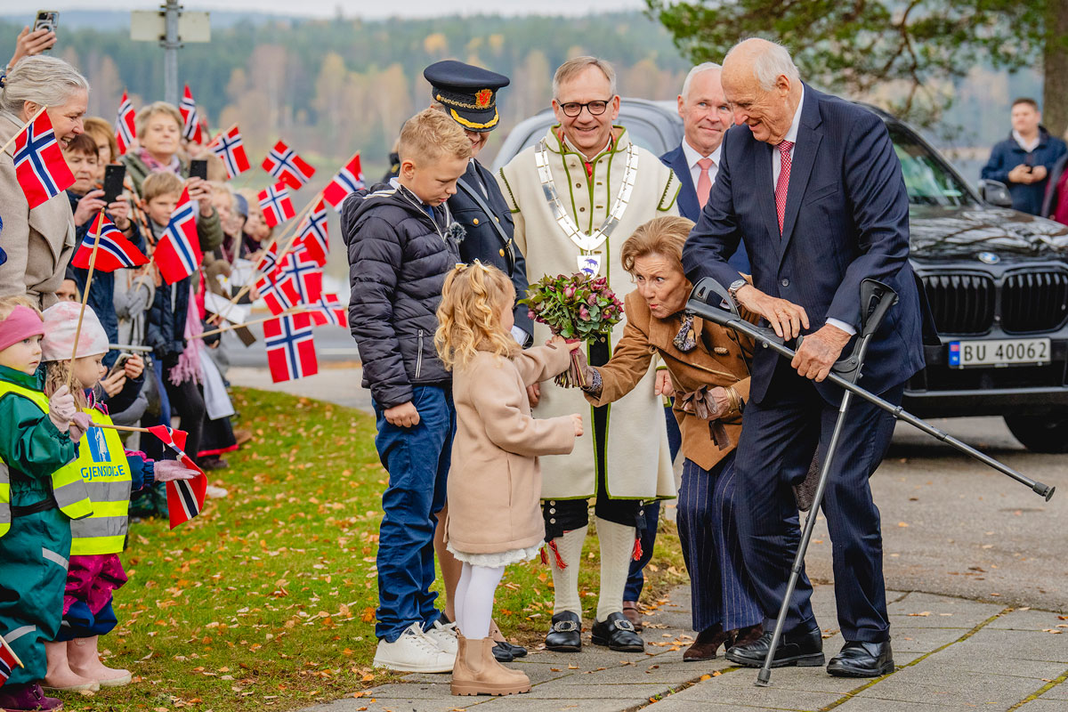 Kong Harald og dronning Sonja før blomster av Ingrid Cornelia Sydnes og Emil Oliver Vestby under besøket til Aremark kommune i Østfold fylke. Etter dette besøket har kongeparet besøkt alle kommunene i Østfold fylke.
