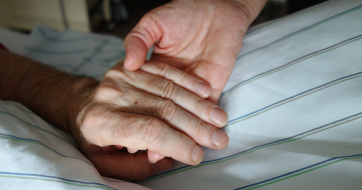 sygeplejerske holder patient i hånden