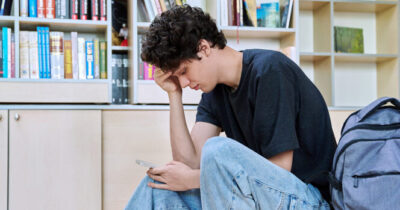 Adolescente scrolla il telefono.