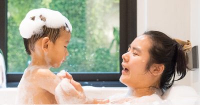 Donna fa il bagno con un bambino.