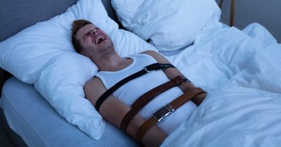 Uomo legato a letto.