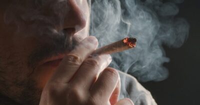 Uomo fuma marijuana.