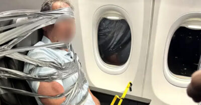Paseggero legato al sedile con nastro adesivo su un aereo.
