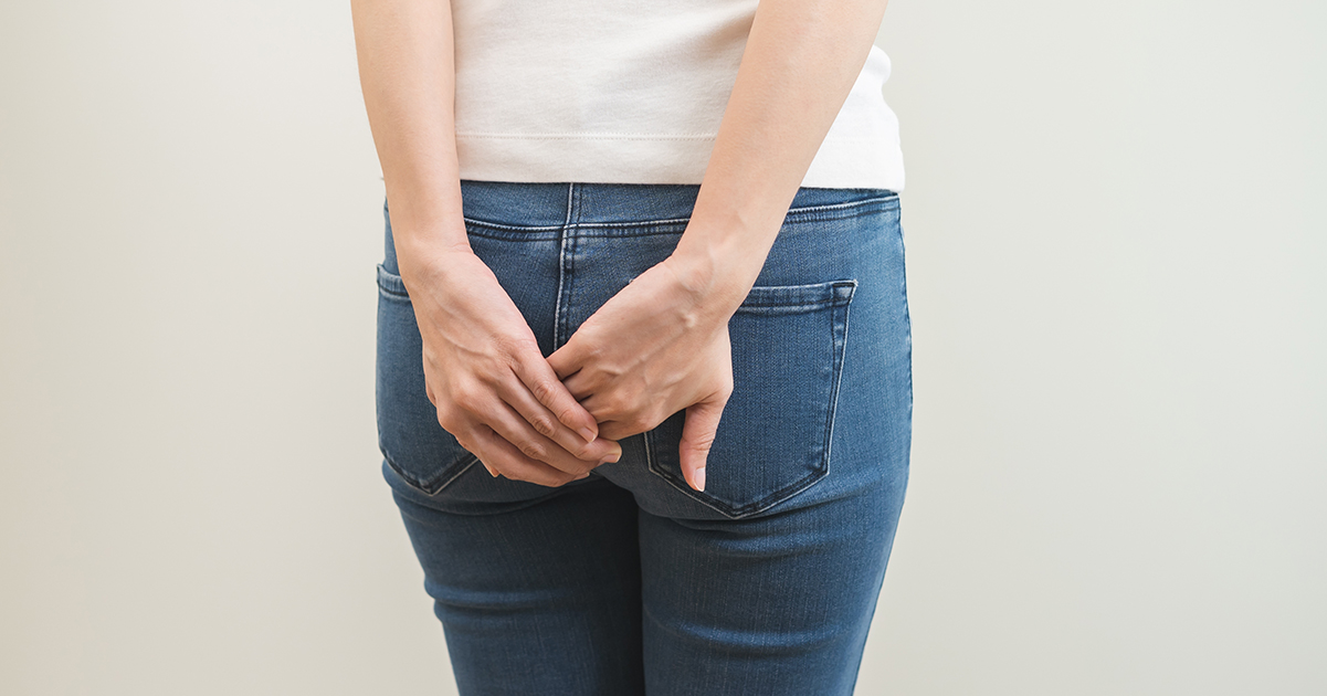 Femme se tient les fesses