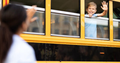 Un enfant faisant signe depuis la fenêtre d'un bus