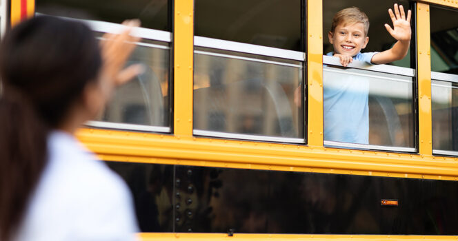 Un enfant faisant signe depuis la fenêtre d'un bus